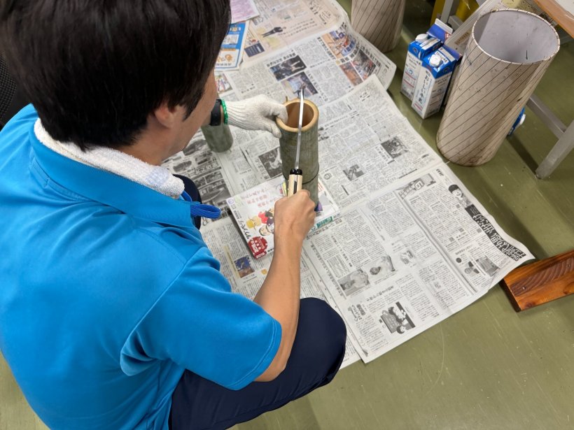 竹をなたで半分にしている